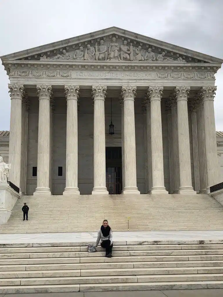 the author sitting on the steps in front of the supreme court