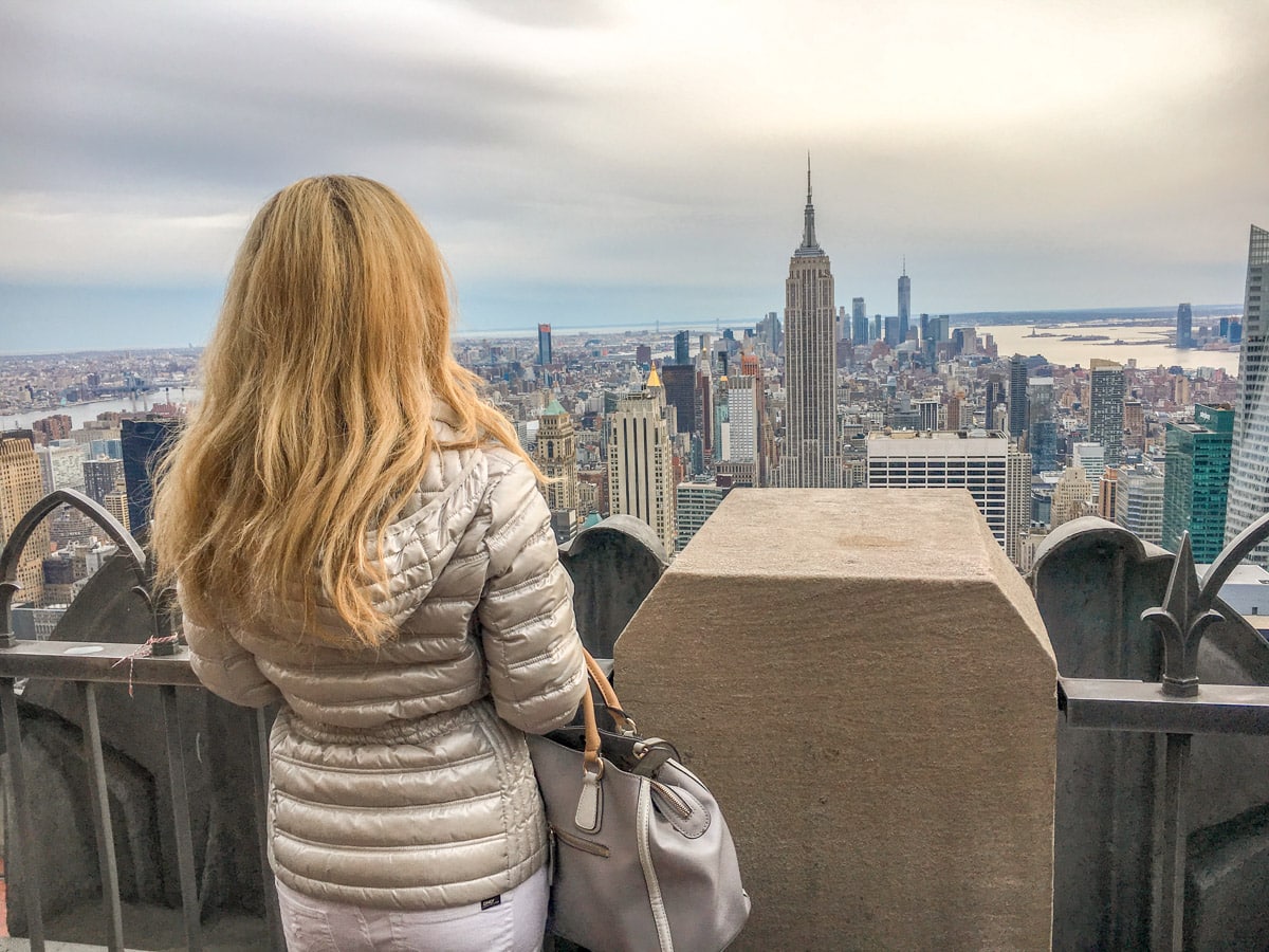 picture of the author standing on the empire state building overlooking the rockefeller center
