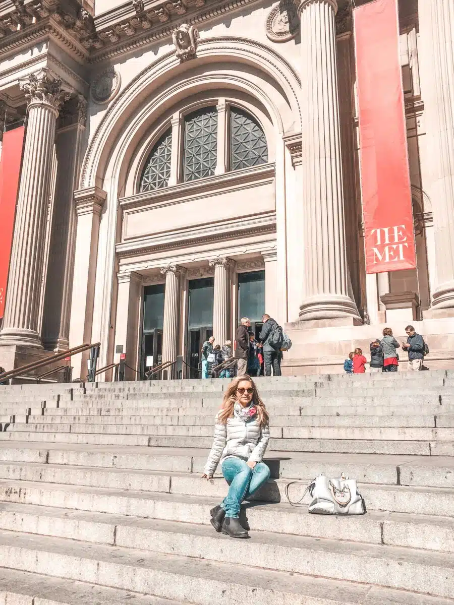 the author in fall sitting on the steps of the met in new york